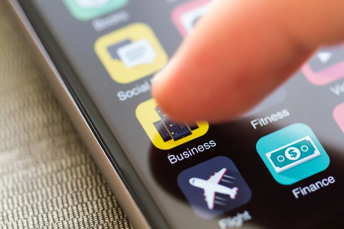 A finger tapping app icons on a smartphone screen