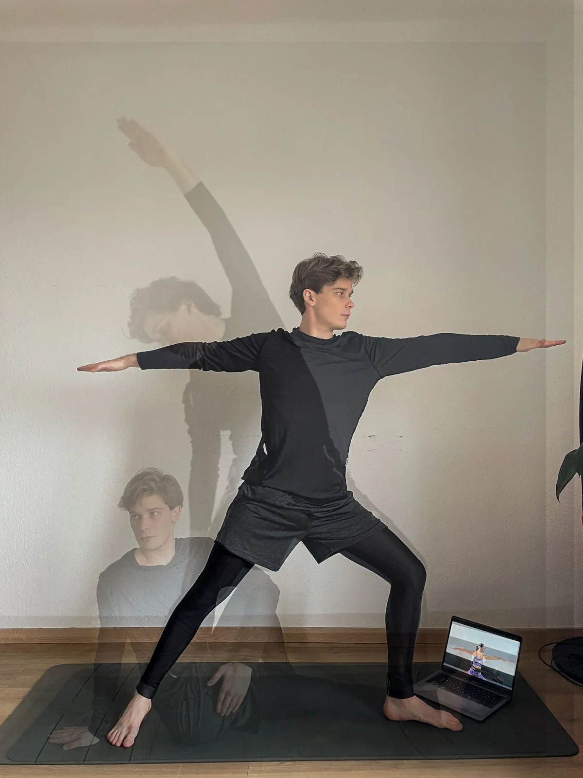 Un créateur en posture de yoga devant un ordinateur portable qui affiche un entraînement en ligne